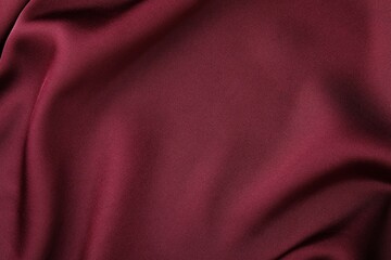 Crumpled burgundy silk fabric as background, top view