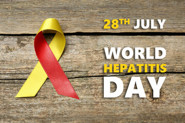 28th july World Hepatitis Day. Yellow-red awareness ribbon on wooden background, top view