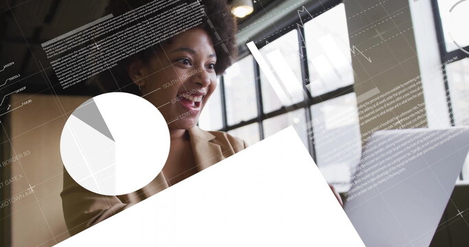 Analyzing woman wearing blazer reviewing overlays at office desk with laptop, pie chart, copy space