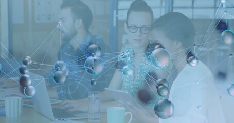 Collaborating three coworkers at office meeting area, with laptop tablet molecular network overlay