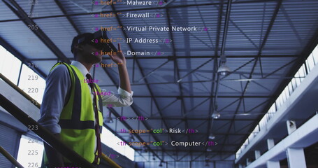 Talking engineer wearing vest hardhat using smartphone on factory catwalk, code overlay, copy space