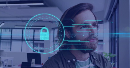 Standing bearded man gazing right in open-plan office near desks, with floating padlock hologram