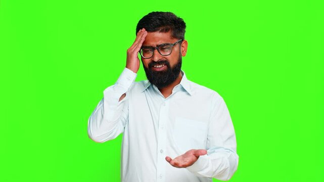 Indian man slaps forehead with hand showing facepalm gesture, expressing regret frustration after clear mistake. Arabian guy isolated on green chroma key background showing emotional realization fail