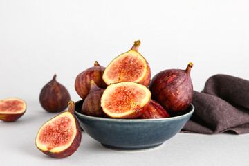 Bowl with fresh ripe figs on white background