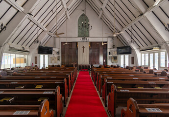 Bright red carpet leads to the altar in St. Marys Cathedral in Kuala Lumpur. High wooden beams and stained glass create a peaceful atmosphere for visitors