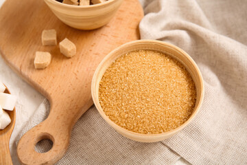 Bowl with brown cane sugar on table