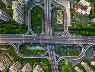 Aerial top down view of a busy junction reveals a multitude of vehicles traveling on various...