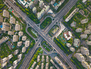 Aerial top down view of a busy junction reveals a multitude of vehicles traveling on various roadways. Hangzhou, China.