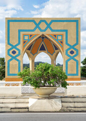 Ornate arch at the Seri Perdana Bridge in Putrajaya, Malaysia, with Islamic geometric mosaic tile patterns against a blue sky
