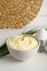 Bowl of fresh mayonnaise on white wooden background