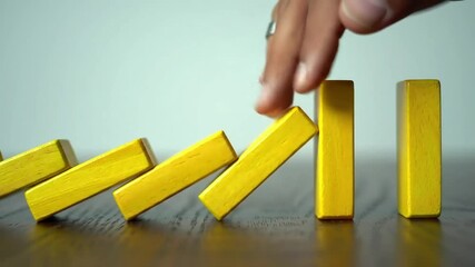 Yellow dominoes in motion cascade on a dark brown wood surface against a pale blue background - Powered by Adobe