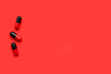 Medical capsules on red background