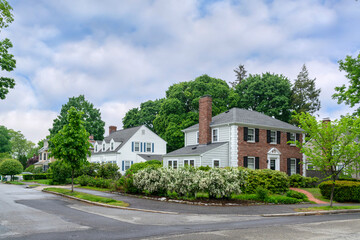 Peaceful residential street corner with vibrant landscaping and historic-style homes in Newton,...