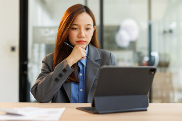 Portrait of Creative young woman working on tablet laptop in her office

