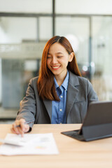 Portrait of Creative young woman working on tablet laptop in her office

