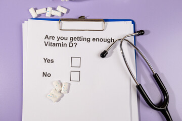 A paper with a health-related question regarding essential vitamins E, placed beside a stethoscope...