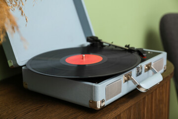 Record player with disk on commode in room