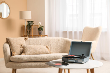 Interior of living room with sofa, record player and disks on coffee table