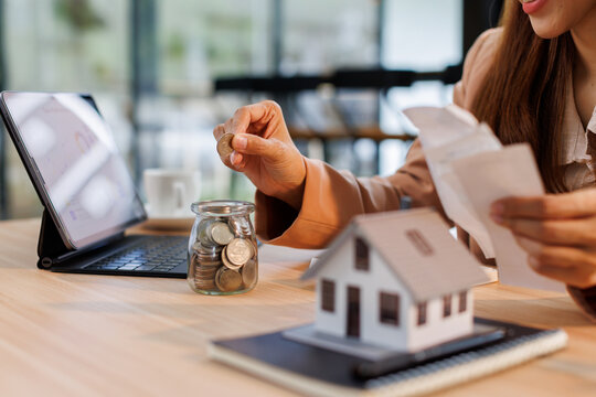 Hand plans home refinance. Pressing calculators, House model, buy or rent, calculators on desk. Saving for property purchase, optimal mortgage payment. Tax, credit analysis for financial planning.
- Powered by Adobe