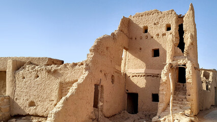 A photo of the old mud houses in Najd, Saudi Arabia, featuring wooden doors, earthen walls, narrow alleys, and handcrafted details that preserve the heritage of our ancestors.
