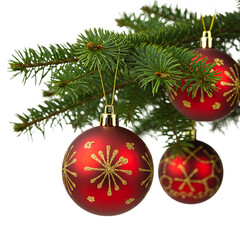 Three red christmas ornaments with gold patterns on a pine branch isolated on white background