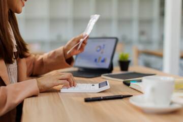 Young woman holding bills working for calculate business data, taxes, bills payment, Start up...