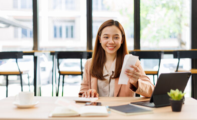 asian young woman hand checking list with bill for calculate accounting expense credit card payment...