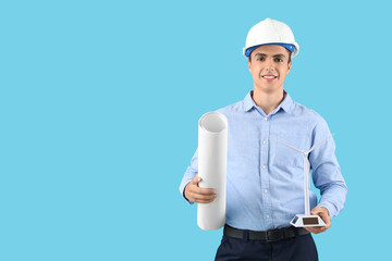 Male engineer with wind turbine model and project on blue background