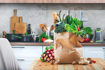 Fresh organic vegetables and baguette in paper bag ready for healthy vegan cooking in the kitchen
