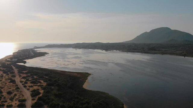 Drone footage captures the serene beauty of Korission Lagoon on Corfu Island, Greece, during sunset.