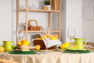 Stylish table setting decorated with many fresh lemons in dining room