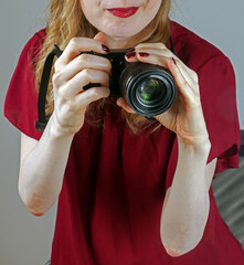 Digital photo camera held by female photographer taking pictures