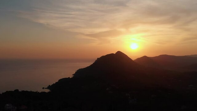 Breathtaking footage capturing the serene sunset over Pelekas Beach and the vast Ionian Sea from a high vantage point in Corfu, Greece.