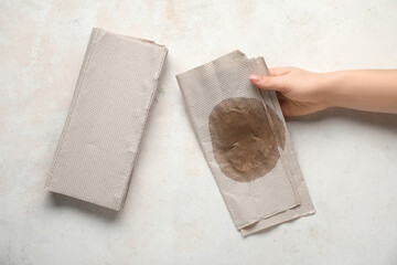 Fototapeta premium Female hand with dirty napkins on grunge grey background