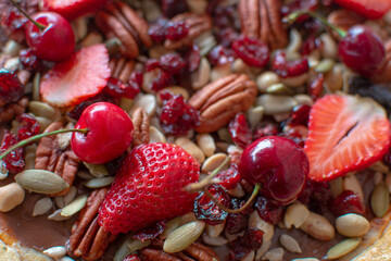 Plano a detalle de un postre de nueces, cacahuates, cereza, fresas, arandanos y chocolate