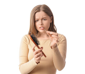 Worried young woman with hair loss problem and brush on white background