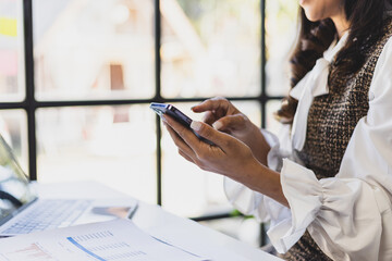 Happy businesswoman using mobile phone and sending messages online on smartphone.