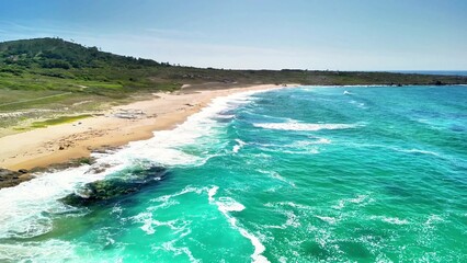 This stunning aerial shot showcases a pristine beach with turquoise waves lapping gently at the...