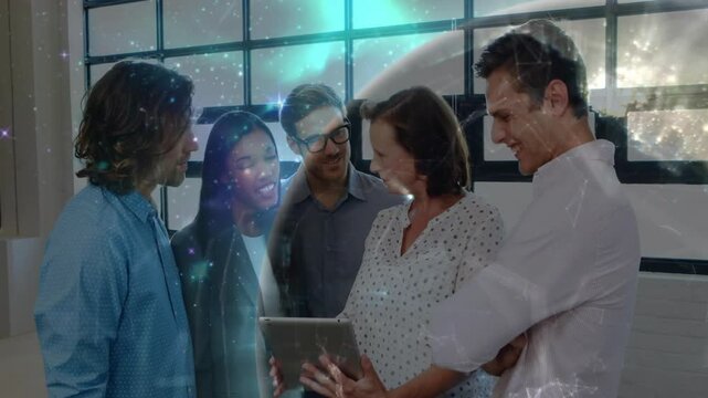 Senior team lead holding tablet and initiating starfield with team discussing data for business