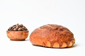 Side view of coffee bun with roasted coffee beans in the little wooden bowl isolated on white background. Coffee bun bread home made. Mexican Coffee Bun. clipping path. close up.