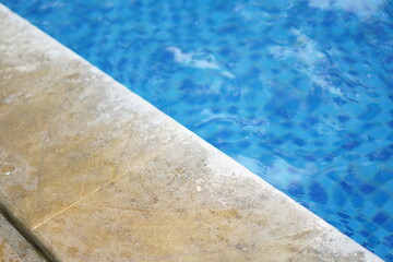 Background of the edge of the swimming pool with blue water