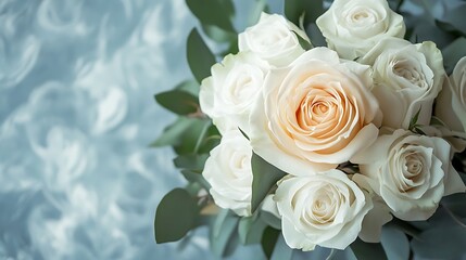 Obraz premium Elegant ivory roses bouquet against a soft, textured blue background creating a serene ambiance