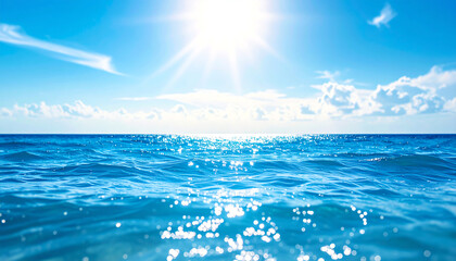 Bright blue ocean waves sparkle under a clear sky, illuminated by the sun, creating a serene and tranquil atmosphere