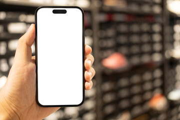 Hand Holding Blank Smartphone Screen in Retail Store. Mobile shopping, online commerce, in-store digital experiences, product information lookup, or advertising with a customizable screen.
