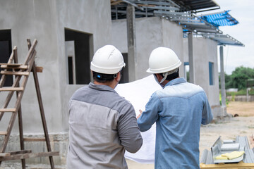 Fototapeta premium Team of Asian foremen, or head engineers construction supervisors wearing white helmet hold blueprint inspect building in workplace site, Professional supervisors discuss or solving problem concept