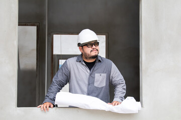 Asian young engineering overweight man wearing safety helmet hard hat at construction site relaxing...