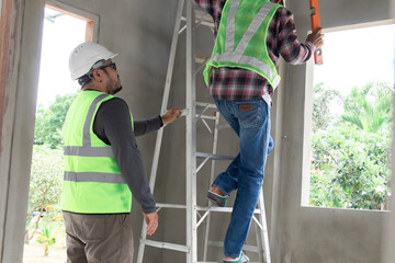 Asian or Indian contractor man business partnership inspect ceiling room mistake labor working...