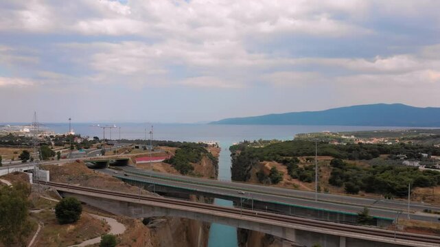 An impressive aerial perspective showcasing the narrow, man-made Corinth Canal in Greece, a significant waterway that cuts through the Isthmus of Corinth, linking the Saronic Gulf of the Aegean Sea wi