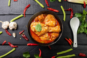 Chicken curry Asian food masala. Traditional cooking healthy food with spices. Arranged on black wooden table background.