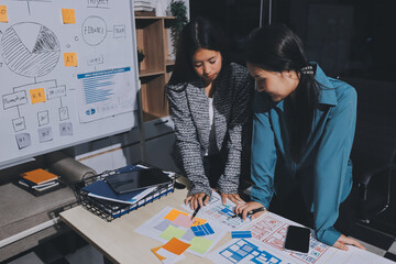 Group of young application developers analyzing uxui mobile app templates during a working meeting
